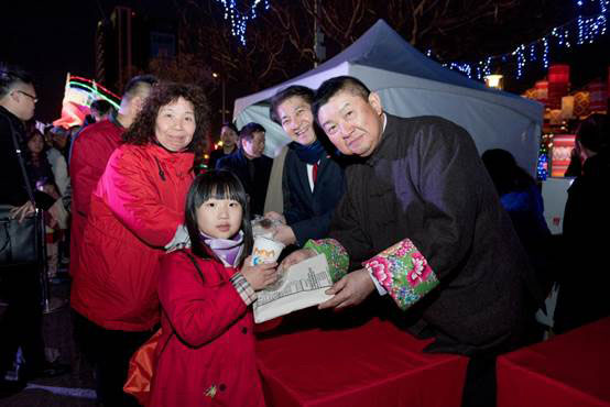 Mr Lie (right) and Mr Chang distributing souvenirs and a Hong Kong delicacy, bowl puddings, to visitors to give them a real taste of Hong Kong.